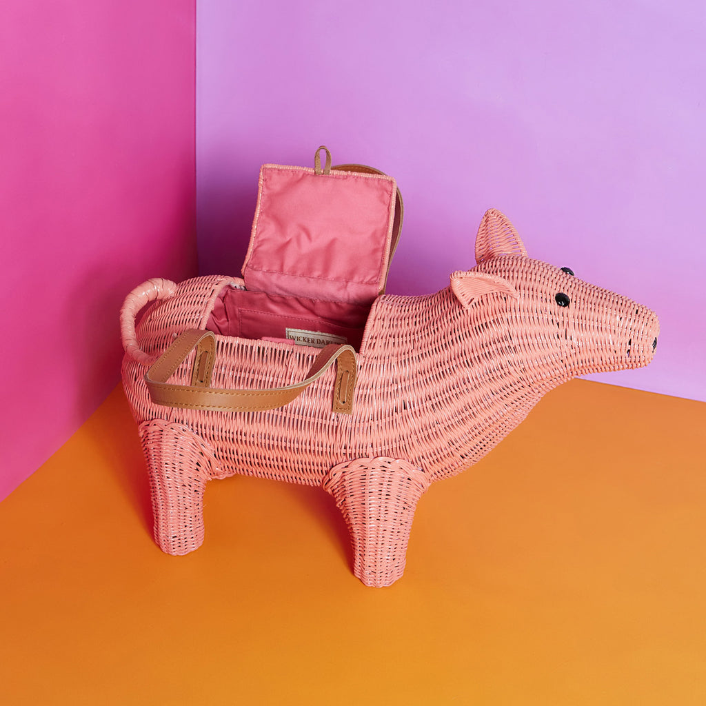 Wicker Darling ham bag pig purse sits in a colourful background