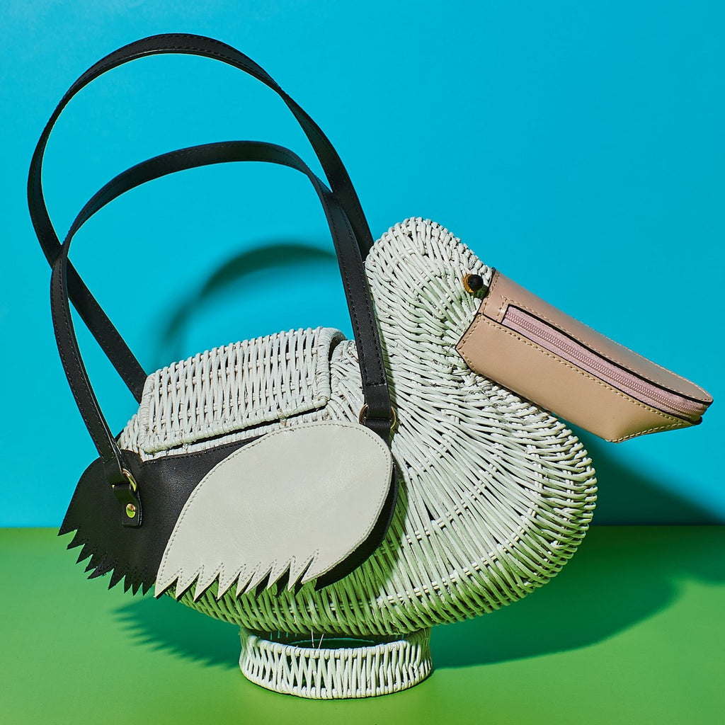 Wicker darling Pelican Bill the Pelican Purse sits in a colourful room