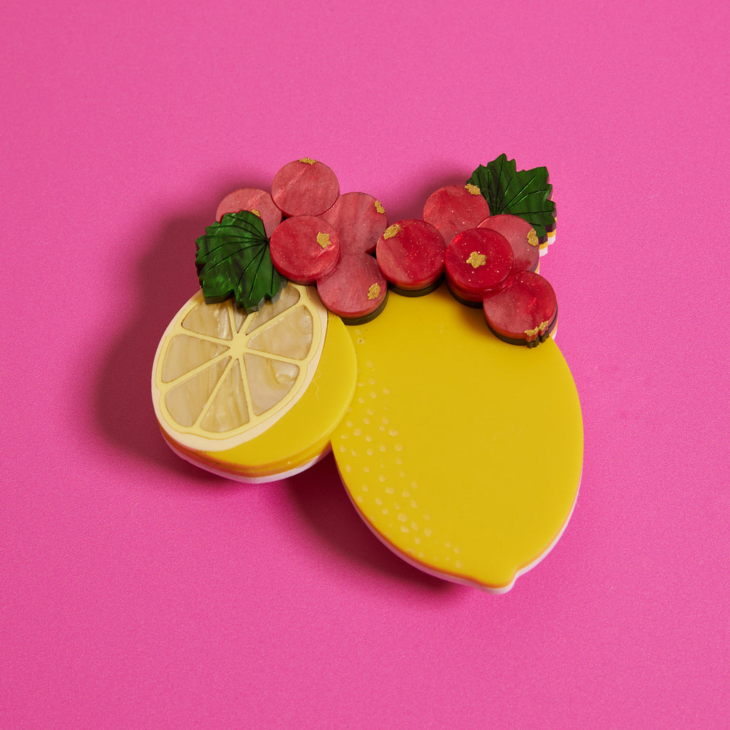 Wicker Darling What Willow Did collab lemon brooch sits in a bright pink background