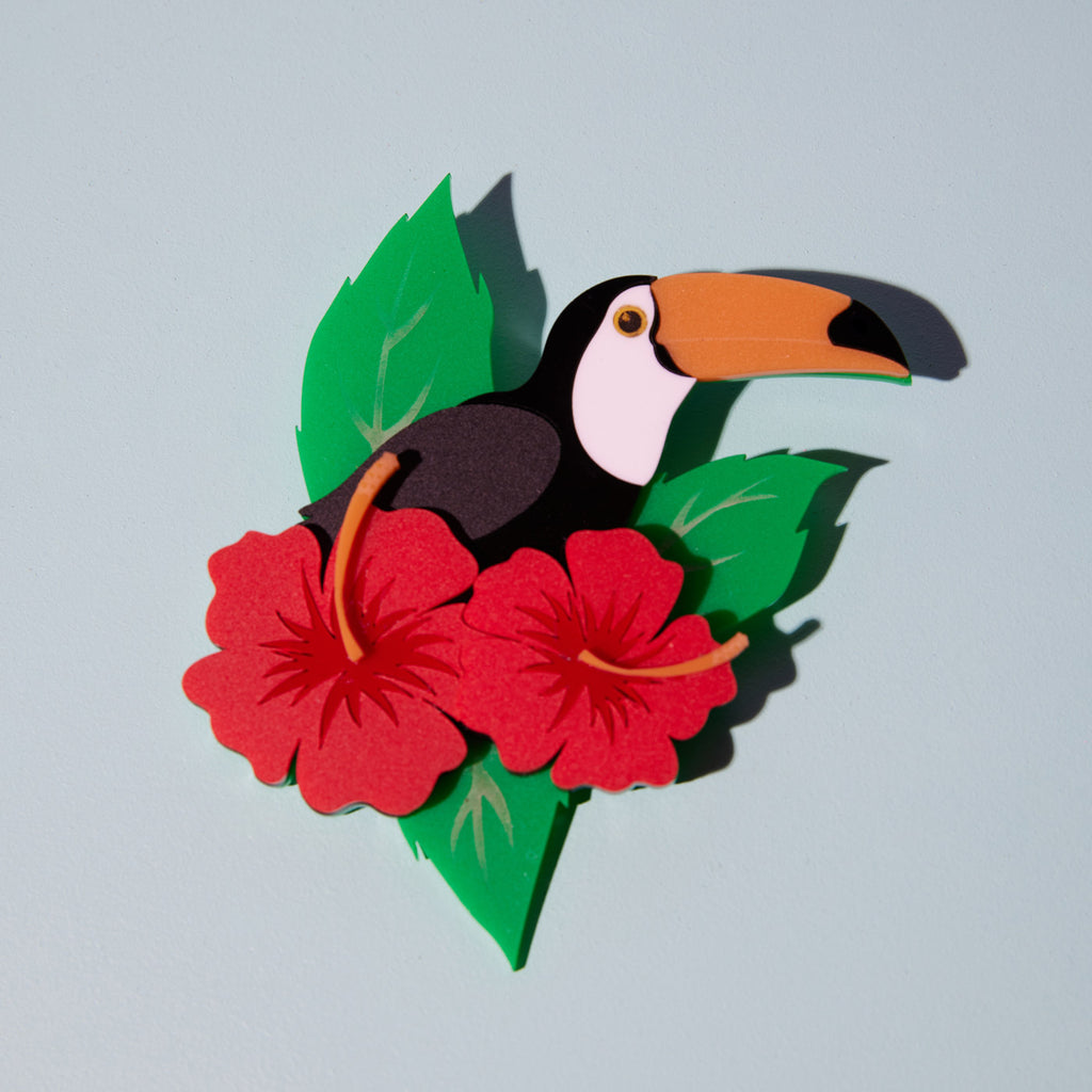 Wicker Darling What Willow Did collab toucan brooch sits in a colourful background
