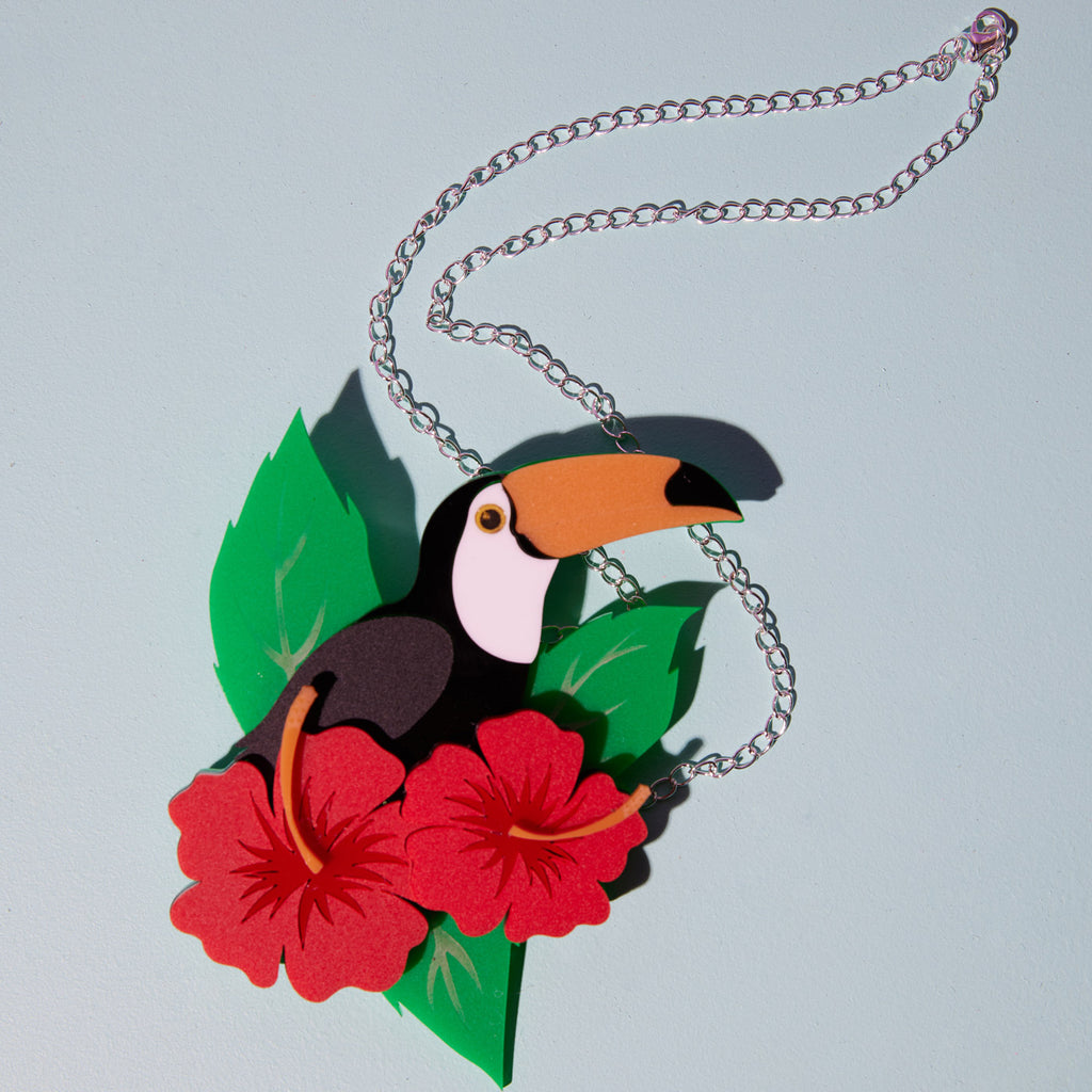 Wicker Darling What Willow Did collab toucan brooch sits in a colourful background