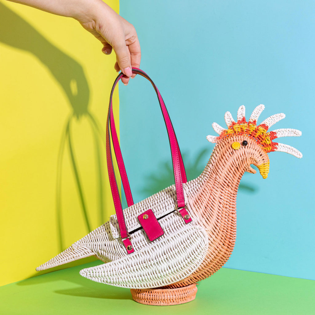 Wicker Darling gary major mitchell cockatoo purse sits in a colourful room