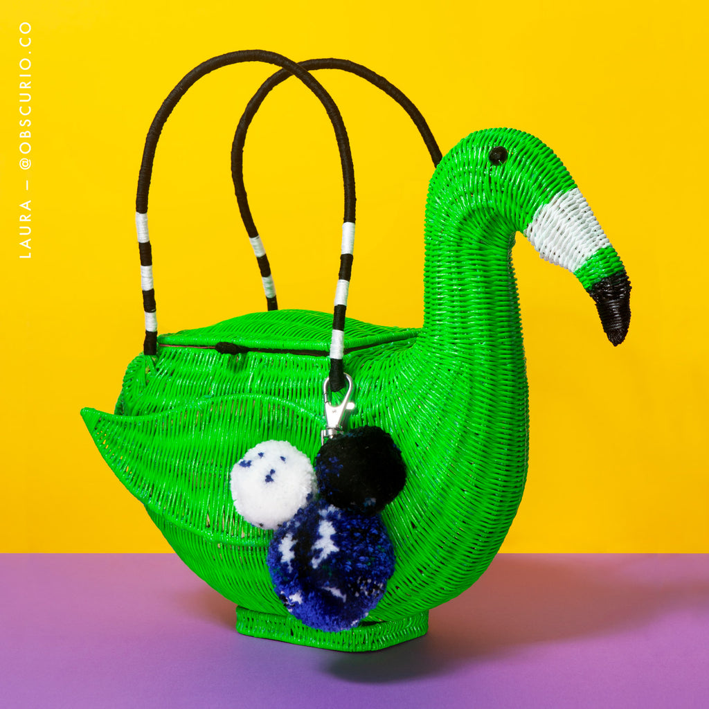 Wicker Darling DIY flamingo basket bird shaped-bag sits in a colourful background