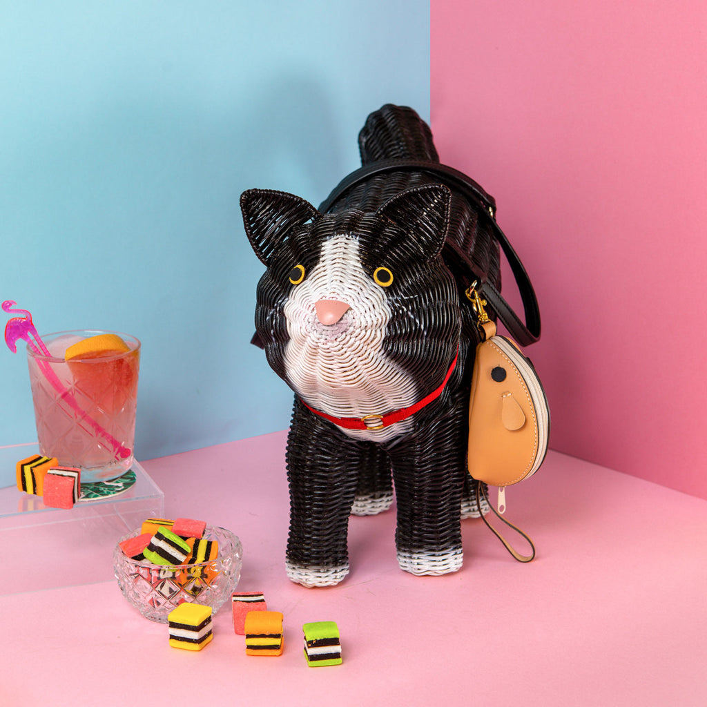 wicker darling oscar the cat purse black cat purse sits in a colourful background