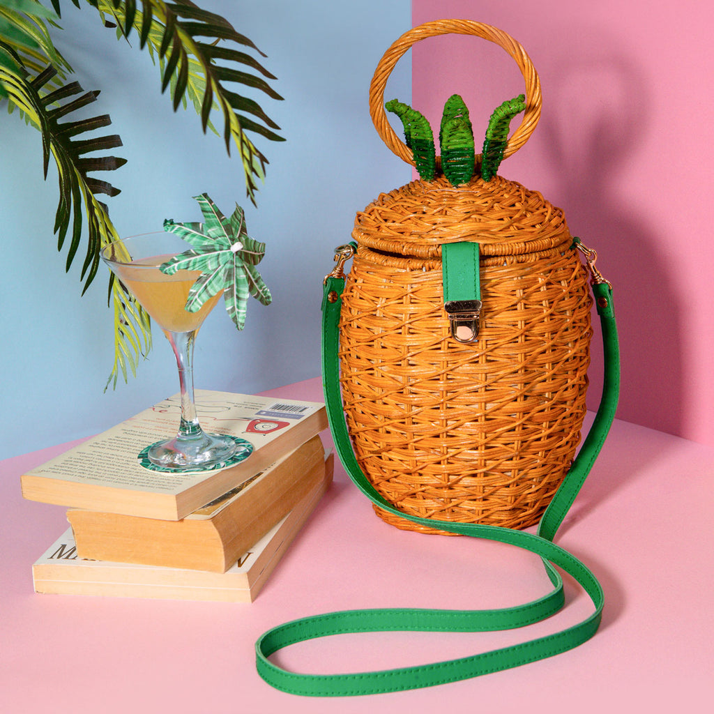 wicker darling fineapple pineapple purse wicker handbag sits in a colourful background