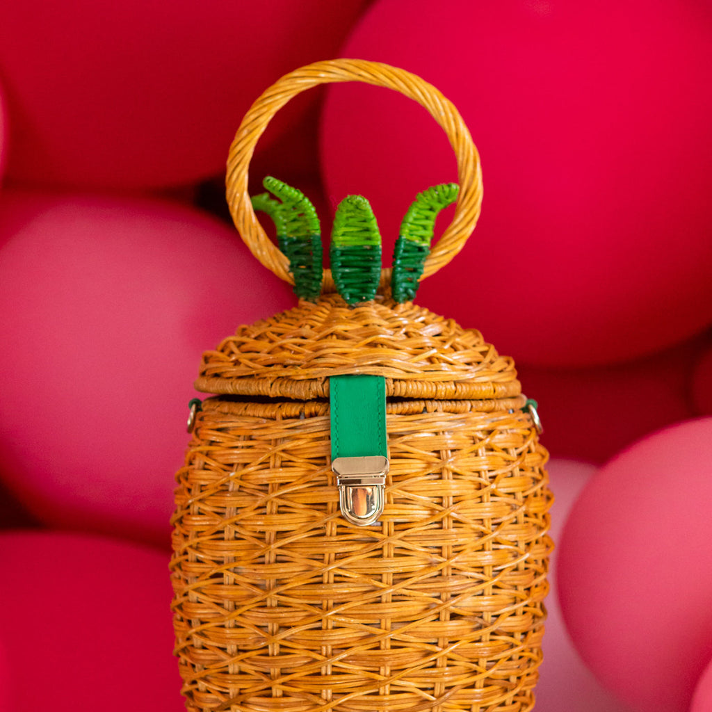 wicker darling fineapple pineapple purse wicker handbag sits in a colourful background